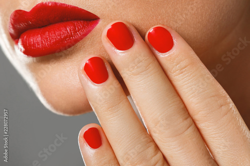 Beauty and cosmetics. Female mouth and nails with red manicure and lipstick. photo
