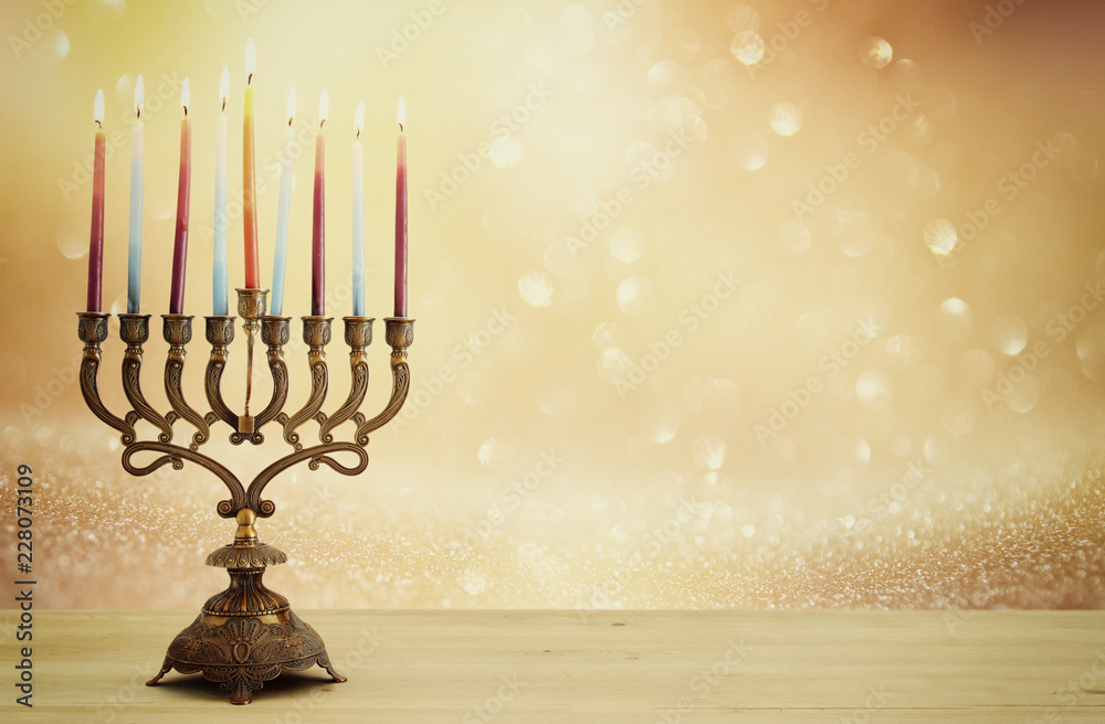 image of jewish holiday Hanukkah background with menorah (traditional candelabra) and candles over glitter shiny background. image of jewish holiday Hanukkah background with menorah (traditional candelabra) and candles over glitter shiny background.