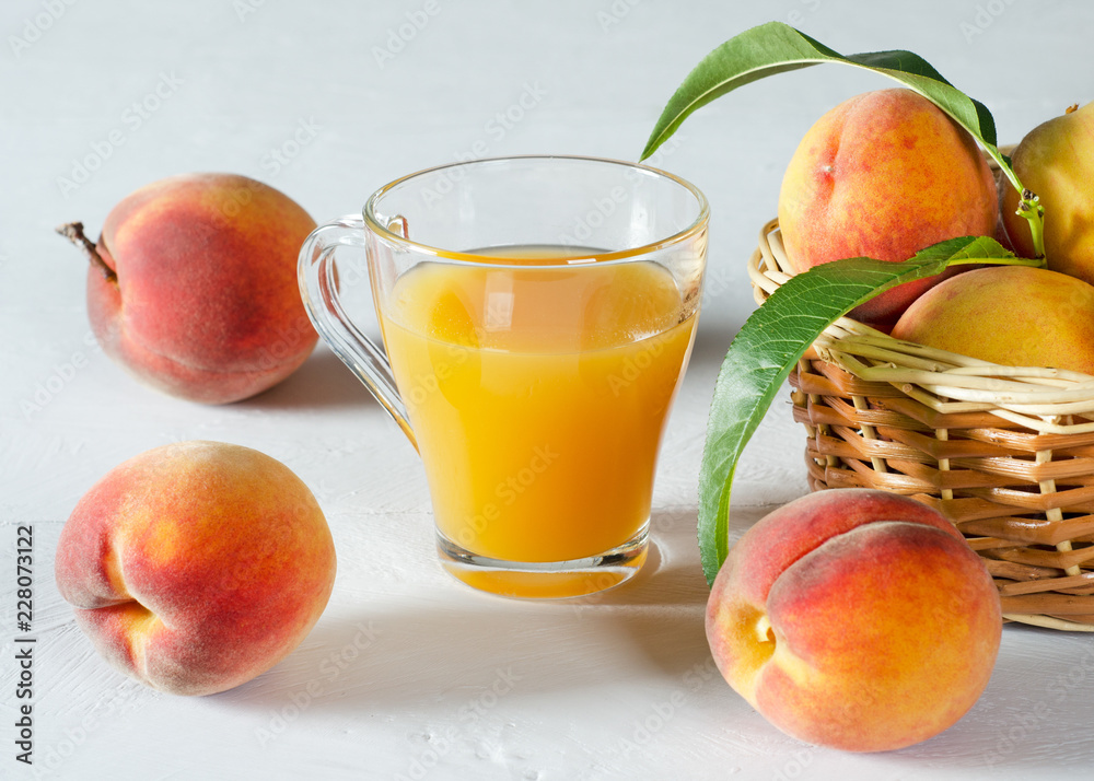 A glass with peach juice and ripe peaches. A glass with peach juice and ripe peaches.