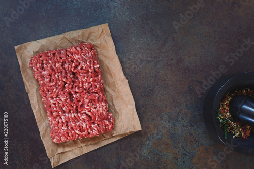 Canvastavla Fresh raw grass fed angus ground beef on parchment paper, concrete rustic backgr