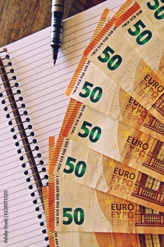 Economía y finanzas. Billetes de 50 euros, cuaderno y bolígrafo.