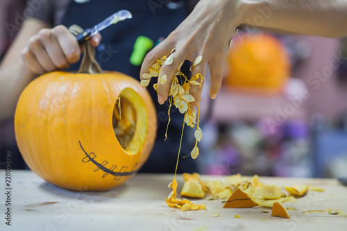 Woman carves a pumpkin for Halloween