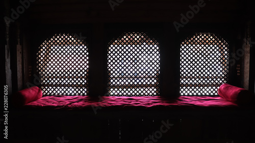 Ankhi jhyal, a traditional wooden Nepalese window, with red bedsheet
 photo