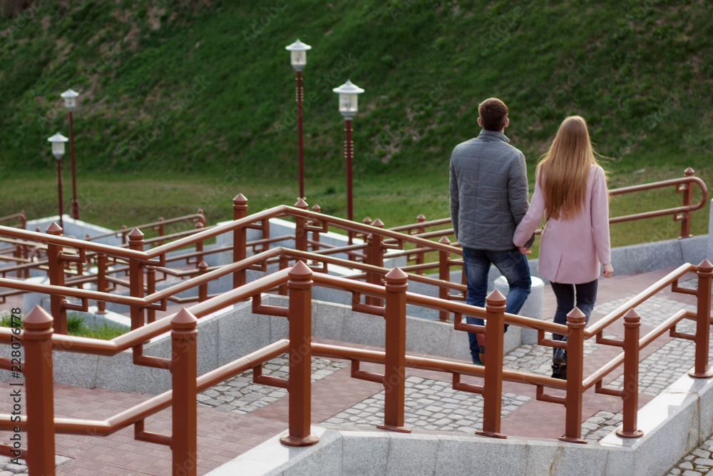 Spring walk of young people walking down the stairs holding hands.