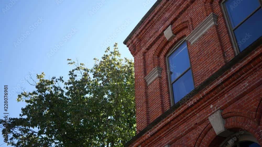 A, establishing shot of second story red brick building near tree A, establishing shot of second story red brick building near tree