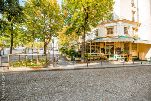 Street view with beautiful buildings and cafe terrace during the morning light in Paris photo
