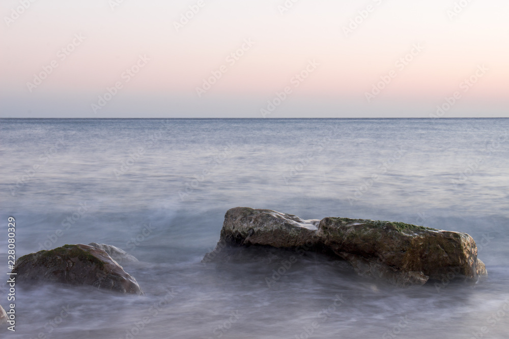 rocks in the sea on sunset