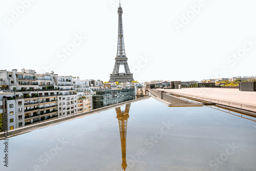 Beautiful cityscape view on Eiffel tower with reflection in the water during the daylight in Paris
