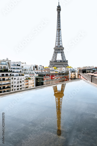 Beautiful cityscape view on Eiffel tower with reflection in the water during the daylight in Paris