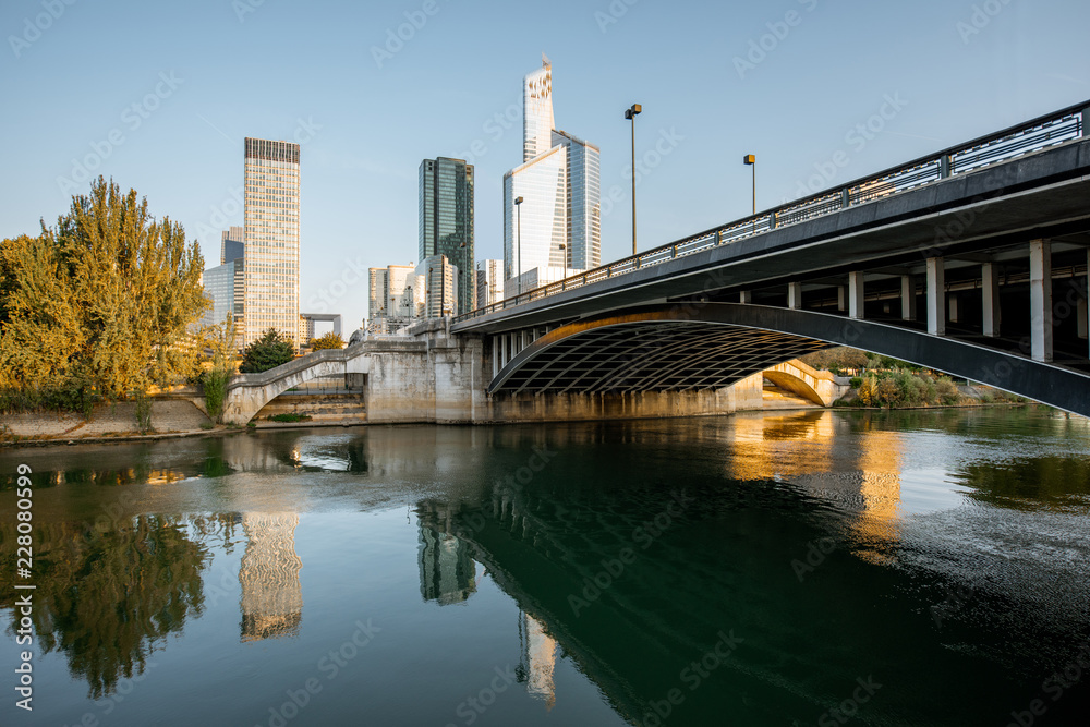 Cityscape view of La Defense financial district with skyscrapers and old bridge during the morning light in Paris