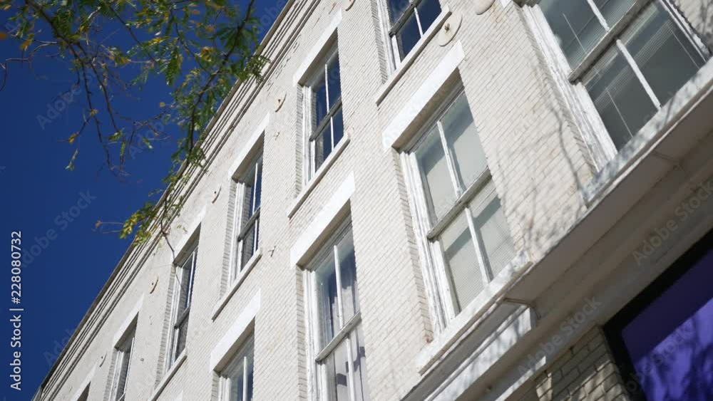 Establishing shot of a white bricked small town building during daytime Establishing shot of a white bricked small town building during daytime