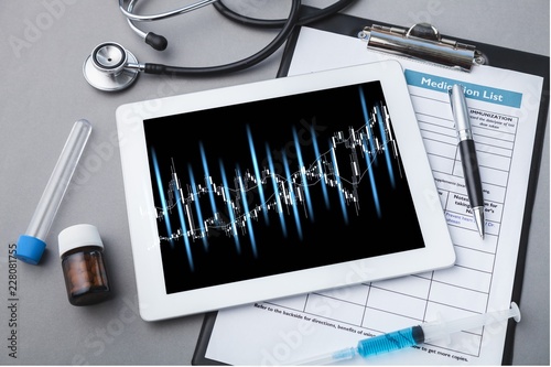 Digital tablet with stethoscope on wooden table