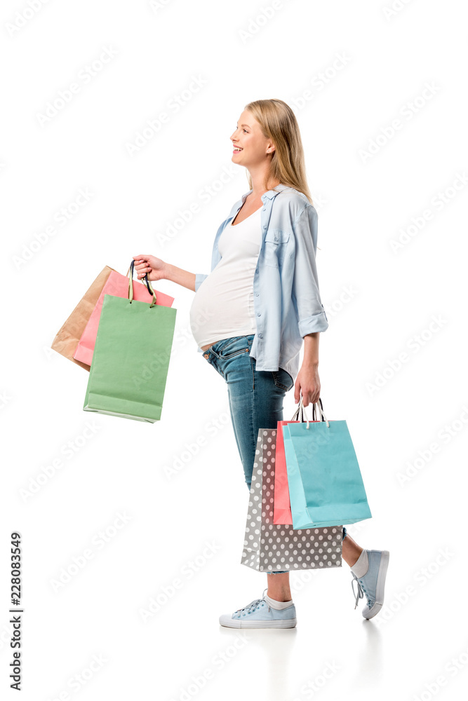 cheerful pregnant mother holding shopping bags isolated on white