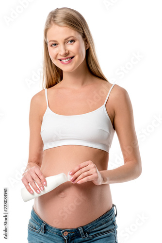 beautiful pregnant woman in white bra holding lotion bottle isolated on white © LIGHTFIELD STUDIOS