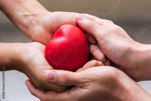 Close up hand giving red heart as heart donor. Valentine day of love concept. Medical ventilator and heart donator charity. Sign of compassion and healthy. Helping doctor hand in freedom life donation
