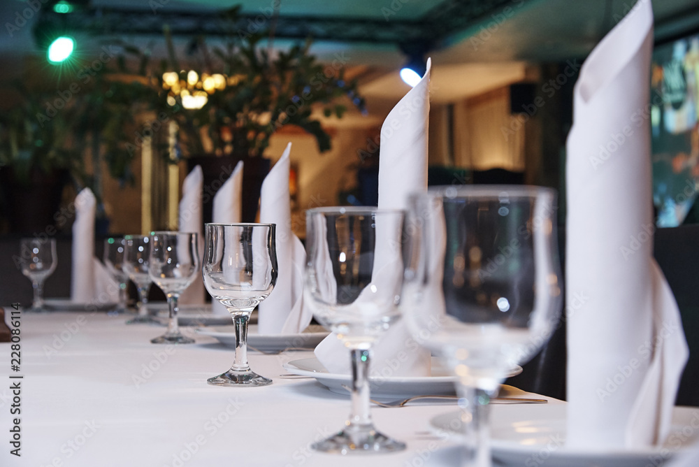 Fototapeta premium Empty wine glass on the banquet table.Table setting for a banquet or dinner party.