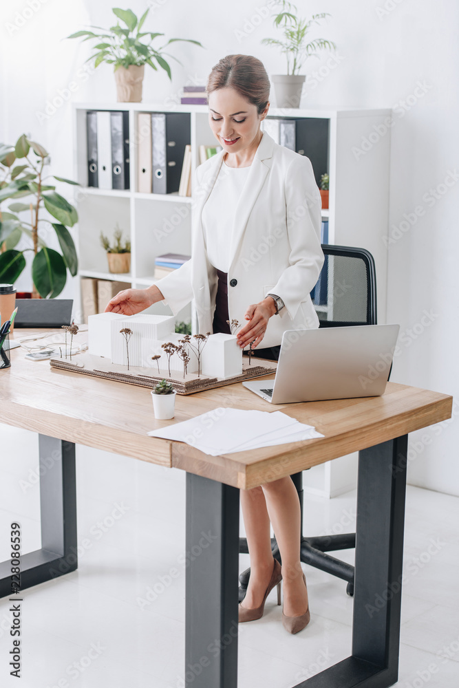 attractive female architect working with house model in office attractive female architect working with house model in office