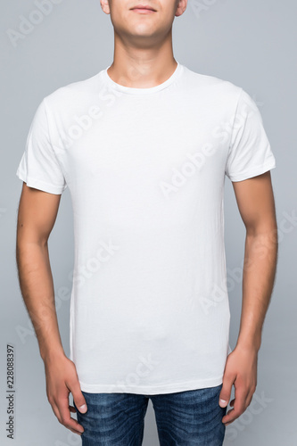 Midsection of young man wearing blank tshirt over white background