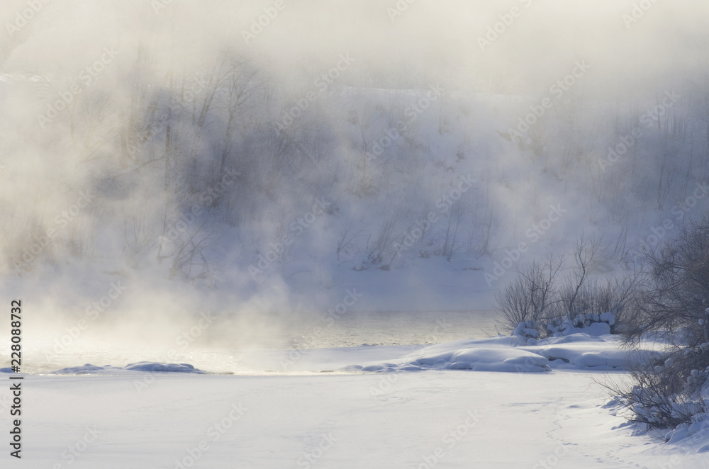 Fog over the river on a frosty morning and white snowy field in winter Fog over the river on a frosty morning and white snowy field in winter