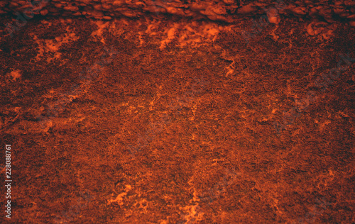 piece of wall of red, orange and yellowish shades, the whole surface is mottled curved small lines and patterns, old texture, shabby appearance, background and texture 