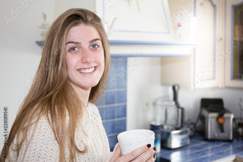 smiling morning girl with tea time in home kitchen