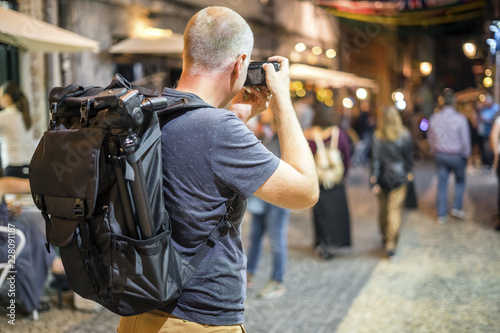 Картината върху платно Photographer taking photos of lively streets with restaurants