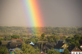 Part of a large rainbow over the private sector, close-up, a rainbow over a residential area of the city