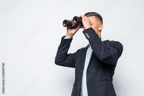 Young business man with binocular on white background
