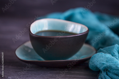 Fototapeta Naklejka Na Ścianę i Meble -  Black coffee in a turquoise cup on a black background. Low key, free space