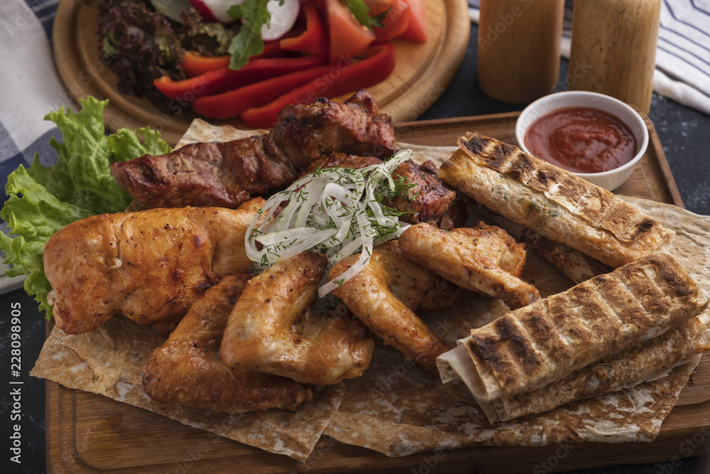 Assorted of grilled meat on wooden board. Bbq pork neck, chicken wings, pork fillet and cheese