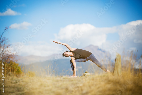 Yoga nel parco. Giovane ragazza pratica yoga all'aperto.