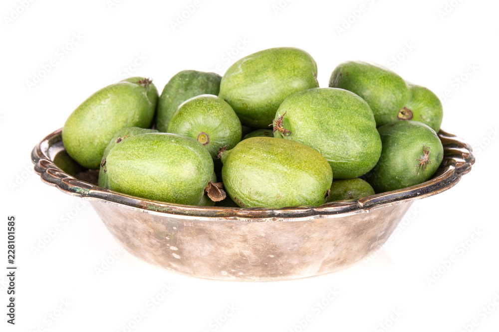 Lot of whole fresh green mini baby kiwi fruit in old iron bowl isolated on white background Lot of whole fresh green mini baby kiwi fruit in old iron bowl isolated on white background
