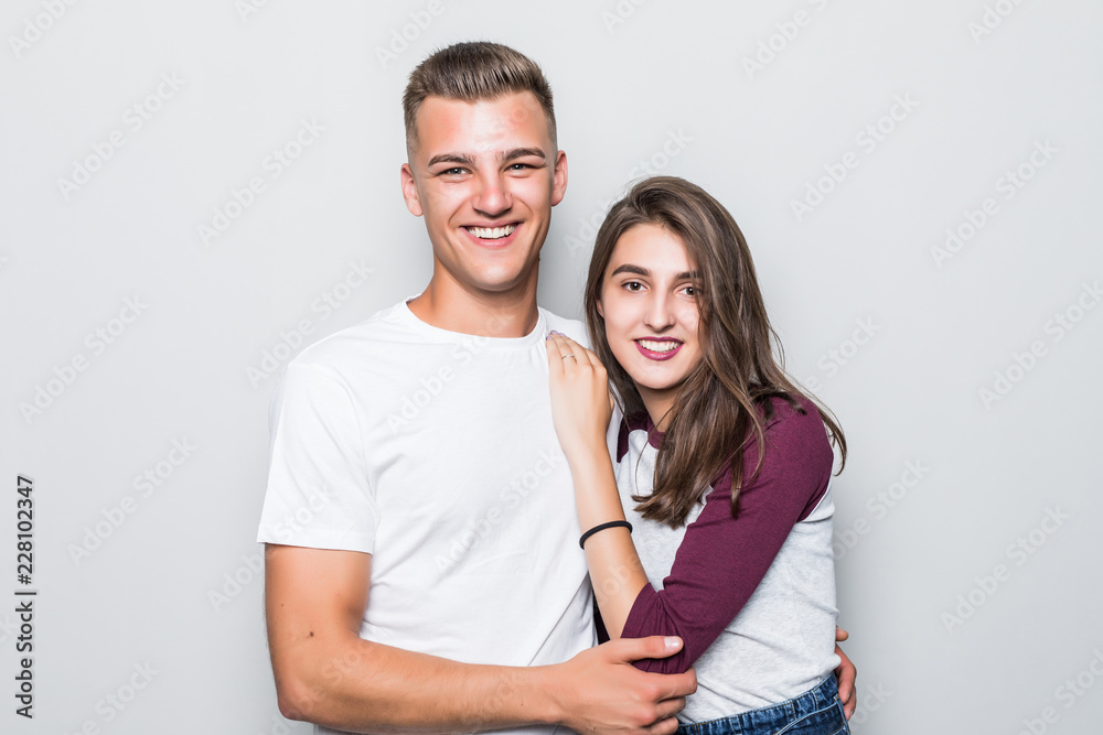 Portrait of happy couple looking at camera against gray background Portrait of happy couple looking at camera against gray background