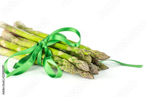 Lot of whole fresh green asparagus spear tied by green ribbon isolated on white background photo