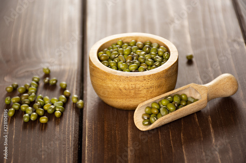 Tableau sur toile Set of lot of whole dry green mung beans with wooden bowl on brown wood