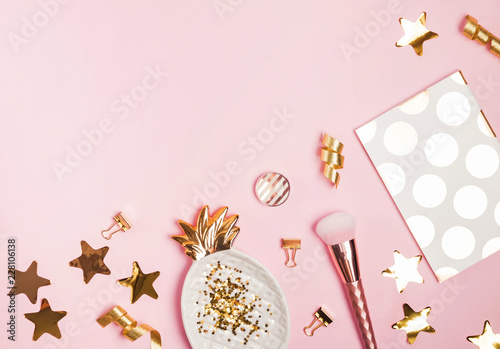 Golden decor and feminine accessories on the pink background 