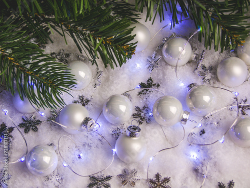 Christmas white balls with a garland under the tree
