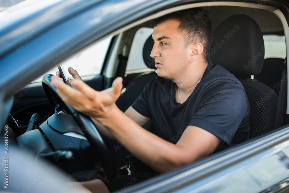 Distracted shocked guy checking his smart phone not paying attention at road annoyed by bad text message email outdoors background