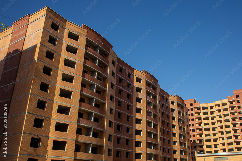 The construction of a new multi-storey residential building for families of bricks. Unfinished multi-storey house