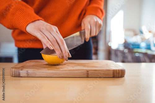 Woman cutting, peeling oranges preparation concept in home kitchen 