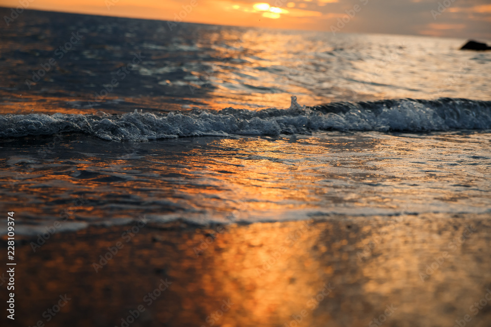 sunset at sea, bottom view, sand at sunset, waves with foam sunset at sea, bottom view, sand at sunset, waves with foam