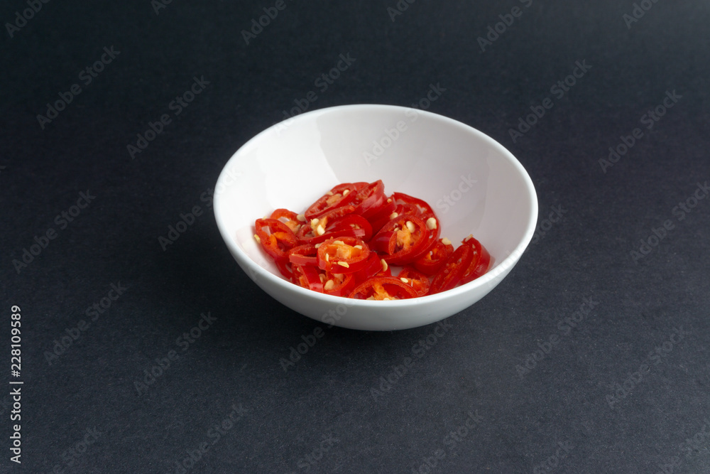 Red chili slices on dark background with selective focus and crop fragment Red chili slices on dark background with selective focus and crop fragment