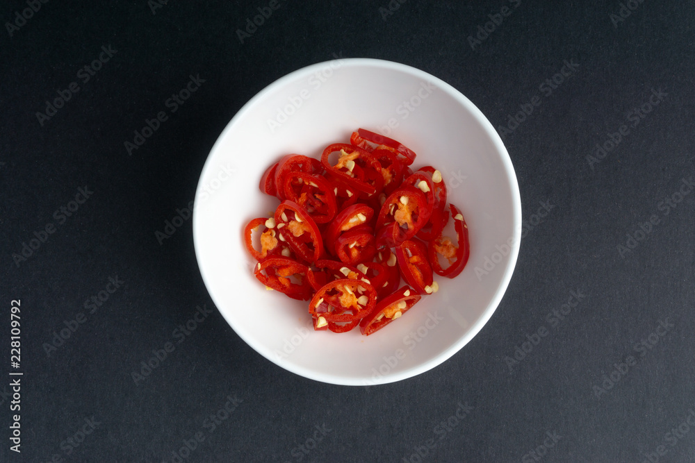 Red chili slices on dark background with selective focus and crop fragment Red chili slices on dark background with selective focus and crop fragment