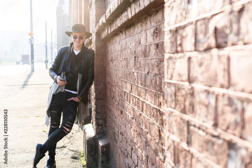 Fototapeta premium Young man posing with a trendy outfit against a urban background.