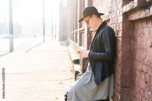 Young man posing with a trendy outfit against a urban background.