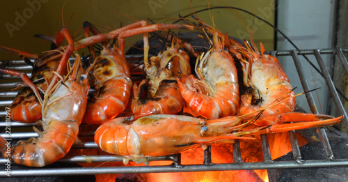 shrimps on grill with flames in background