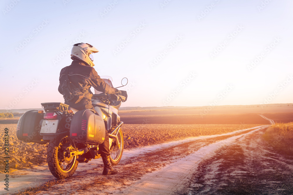 Fototapeta premium Motocyklista podróżujący, jesienny dzień, motocykl terenowy, jeździec siedzący na rowerze i patrzący na odległość, poszukiwacz przygód, turystyka ekstremalna, ubrania na zimną pogodę