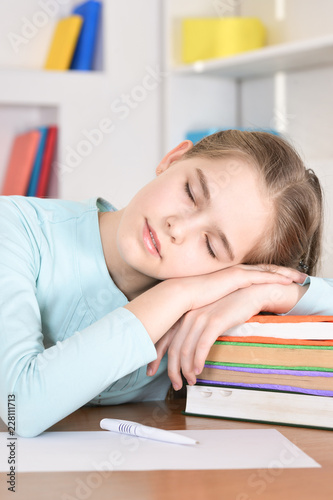 Portrait of a cute schoolgirl sleeping at table