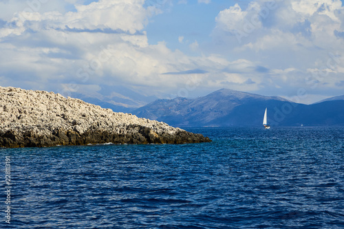 View on sail, rocks and mountain on trip from Lefkada to Kalamos