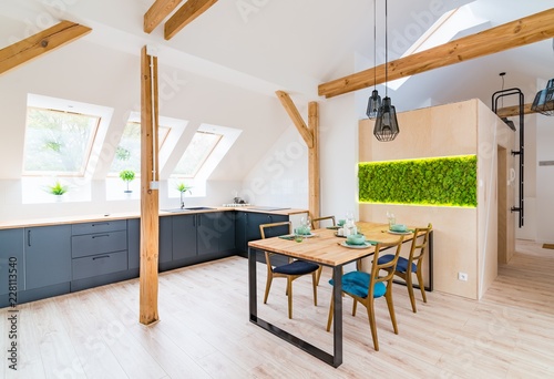 Wooden set table and modern kitchen in the attic